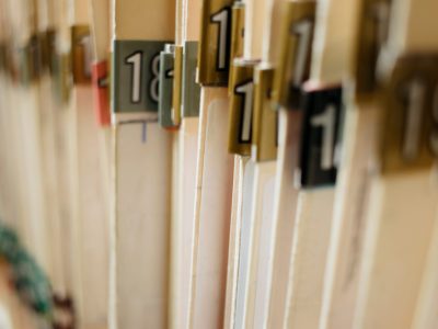 various medical record charts and folders in cabinet and on shelve sorted alphabetically and numerically